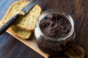 Black Olive Tapenade in Jar with Knife and Bread.