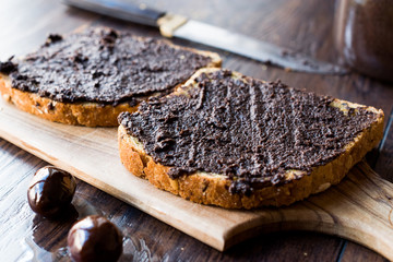 Black Olive Tapenade on Bread with Knife and Jar