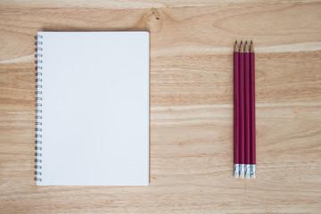 pencil and book on wood background