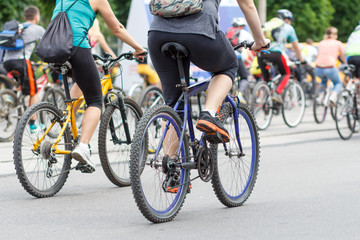 Fototapeta na wymiar Young men and women cycling on city street