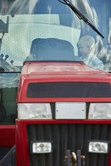 Little blond boy playing in tractor, outdoors