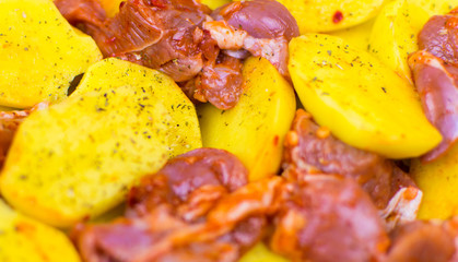 Raw cut potatoes and pieces of meat.