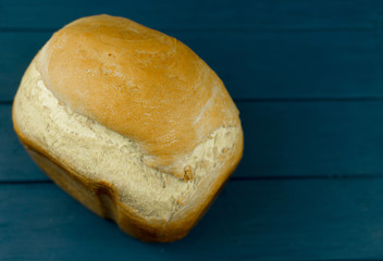 A loaf of homemade white bread on   wooden background.