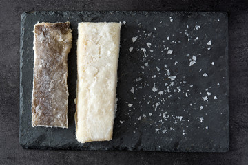 Salted dried cod on black stone top view copyspace. Typical Easter food