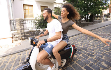 Obraz premium Stylish young couple sits a scooter in the street.