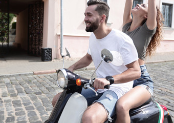 Happy young couple having fun on a scooter