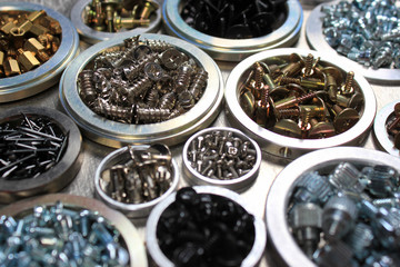 Screws, bolts and nuts on metal background
