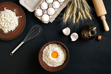 Pasta cooking ingredients on black kitchen table. Top view with space for your text