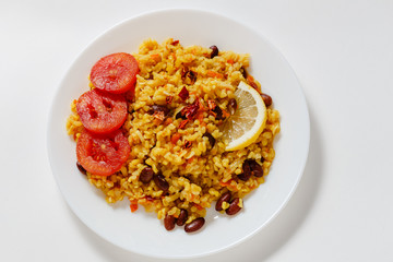 bulgur pilaf with beans, barberry, paprika, garlic, tomato, lemon and spices on white background