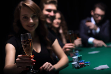 fashion woman with glasses of wine,sitting at a table in a casino