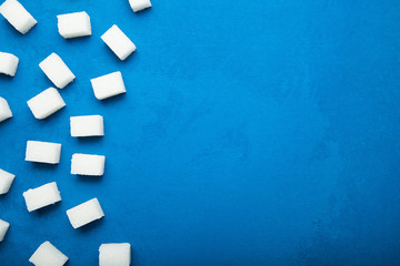 Cubes of white sugar on a blue vintage background, concept. Copy space.