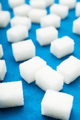 Close-up, cubes of sugar on a blue background. Selective focus.