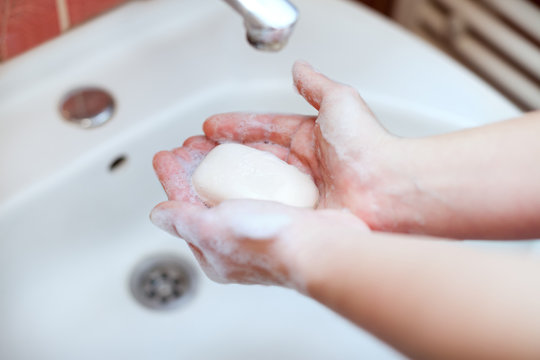 Soapy hands holding soap for hand washing