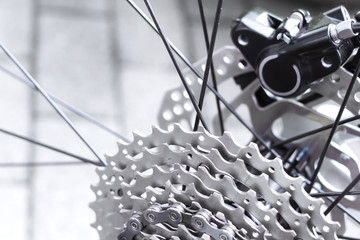 Bicycle gear, disk brake and metal chain rings detail, close up shot of a black hydraulic...