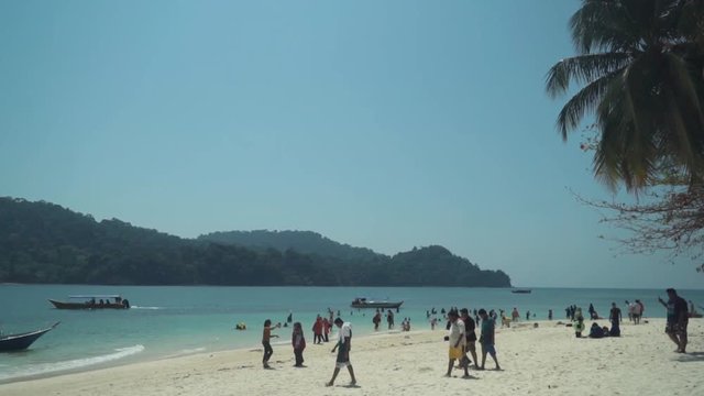 Slow motion tourists walking on Pulau Beras Basah in Langkawi.