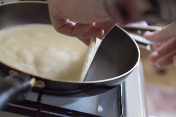 a man cooking pancakes in a frying pan