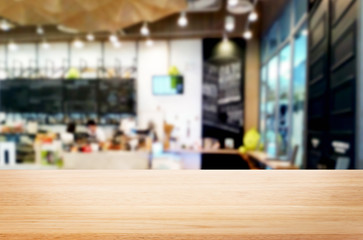 Selected focus empty brown wooden table and Coffee shop or restaurant blur background with bokeh image. for your photomontage or product display.