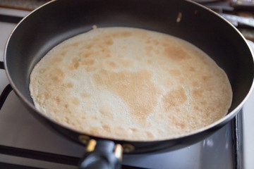 a man cooking pancakes in a frying pan