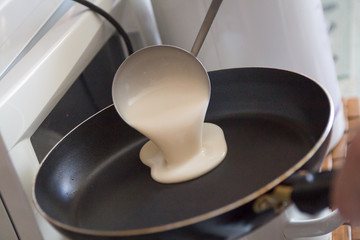 a dough for pancakes poured int a frying pan