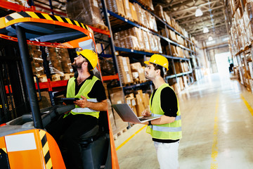 Warehouse workers working together with forklift loader