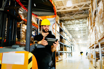 Obraz premium Warehouse worker doing logistics work with forklift loader