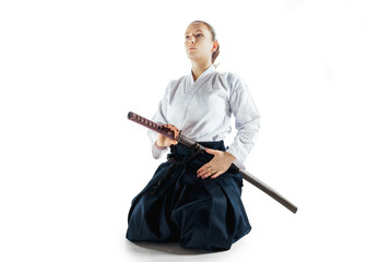 Aikido master practices defense posture. Healthy lifestyle and sports concept. Woman in white kimono on white background.