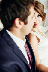 Groom and bride posing and smiling in studio for wedding shot. Wedding. Wedding day. Beautiful bride and elegant groom after wedding ceremony. 