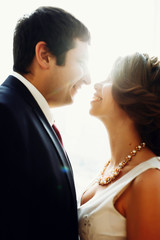 Groom and bride posing and smiling in studio for wedding shot. Wedding. Wedding day. Beautiful bride and elegant groom after wedding ceremony. 