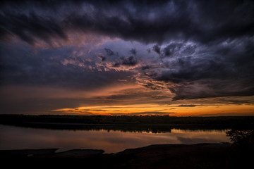 Dramatic sunset clouds near a river