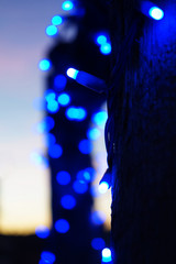 Fototapeta na wymiar Abstracto de luces azules con el atardecer al fondo 