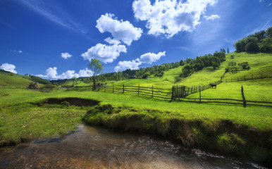 Green hills with fences and a donkey grazing