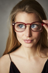 Fototapeta premium Beautiful big blue eyes through glasses, studio