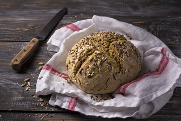 Simple rustic rye oat bread without yeast with seeds on a wooden table, selective focus