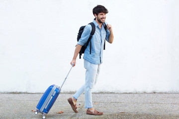 Full body travel man with bag pulling suitcase
