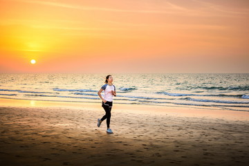 Girl running on the beach at sunset