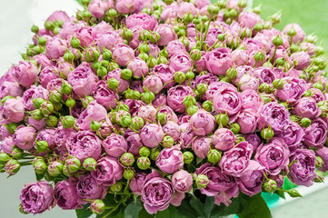 Obraz na płótnie Canvas A huge bouquet of small pink roses of modern varieties in the bouquet as a gift. Background. Selective focus.