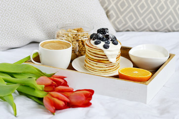 Cup with Cappuccino and Homemade Pancakes Sour Cream Berries Granola Orange Healthy Breakfast Morning Concept Woman's 
Day Flowers Tulips Daffodils