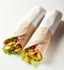 Two takeaway tortilla wraps with avocado