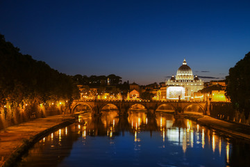 Fototapeta na wymiar Night view of St. Peter's Basilica. Ponte Sant Angelo and Tiber River in Rome - Italy. Dramatic sunset with sbeautiful water reflection. Italy postcard