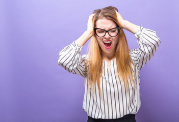 Young woman feeling stressed on a solid background