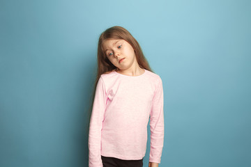 Obraz premium The thoughtful girl. Teen girl on a blue background. Facial expressions and people emotions concept