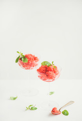 Healthy low calorie summer treat. Strawberry and champaigne granita or shaved ice dessert with fresh mint in champaigne glasses, white background, copy space. Clean eating, vegetarian food concept