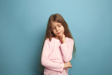 The thoughtful girl. Teen girl on a blue background. Facial expressions and people emotions concept