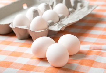 Chicken eggs on a table with a checkered tablecloth. Top view.