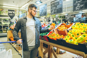 man seek vegetables in supermarket