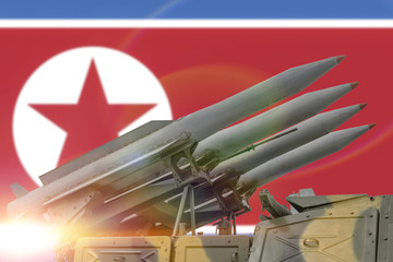 concept four rockets sent upwards against the background of the flag of North Korea. Weapons of...