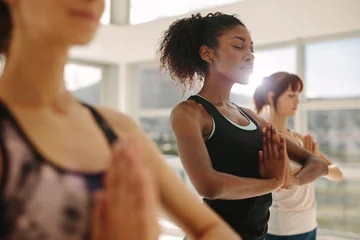 Selbstklebende Fototapete Yogaschule Frau praktiziert Yoga mit Freunden im Fitnessstudio