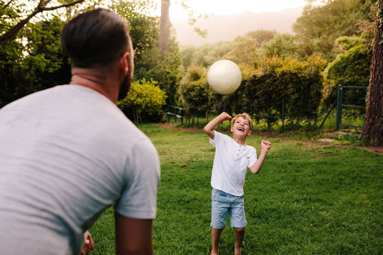 Father and son playing with a football
