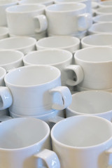Fototapeta na wymiar A lot of empty white porcelain cups on a table