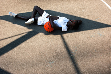 Dreamy afro-american model in white with basketball in shade